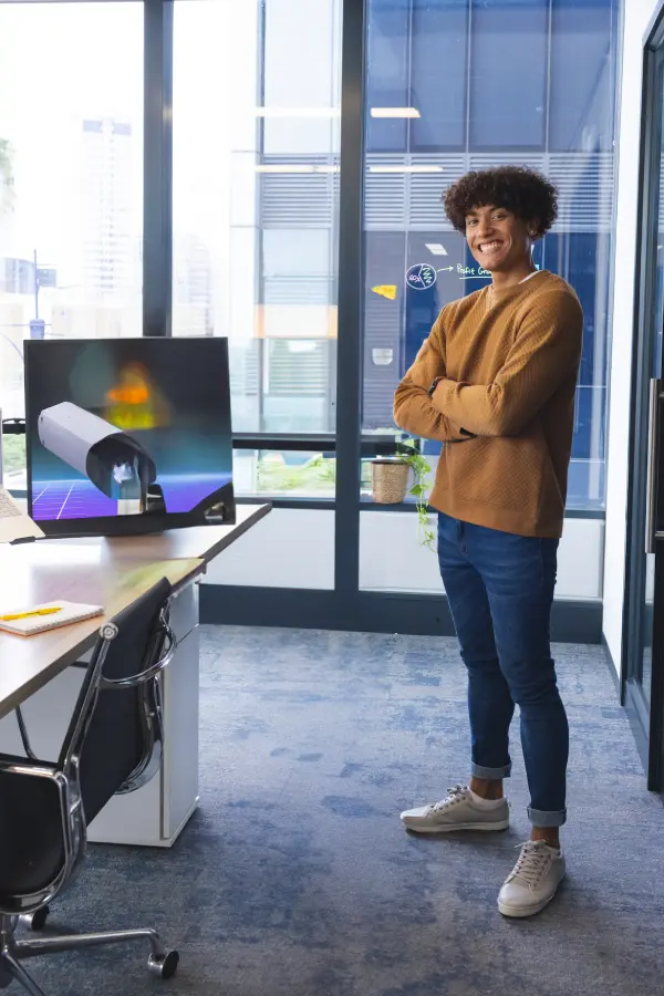smiling-young-man-standing-confidently-in-modern-o-2025-04-03-11-52-37-utc-1.webp